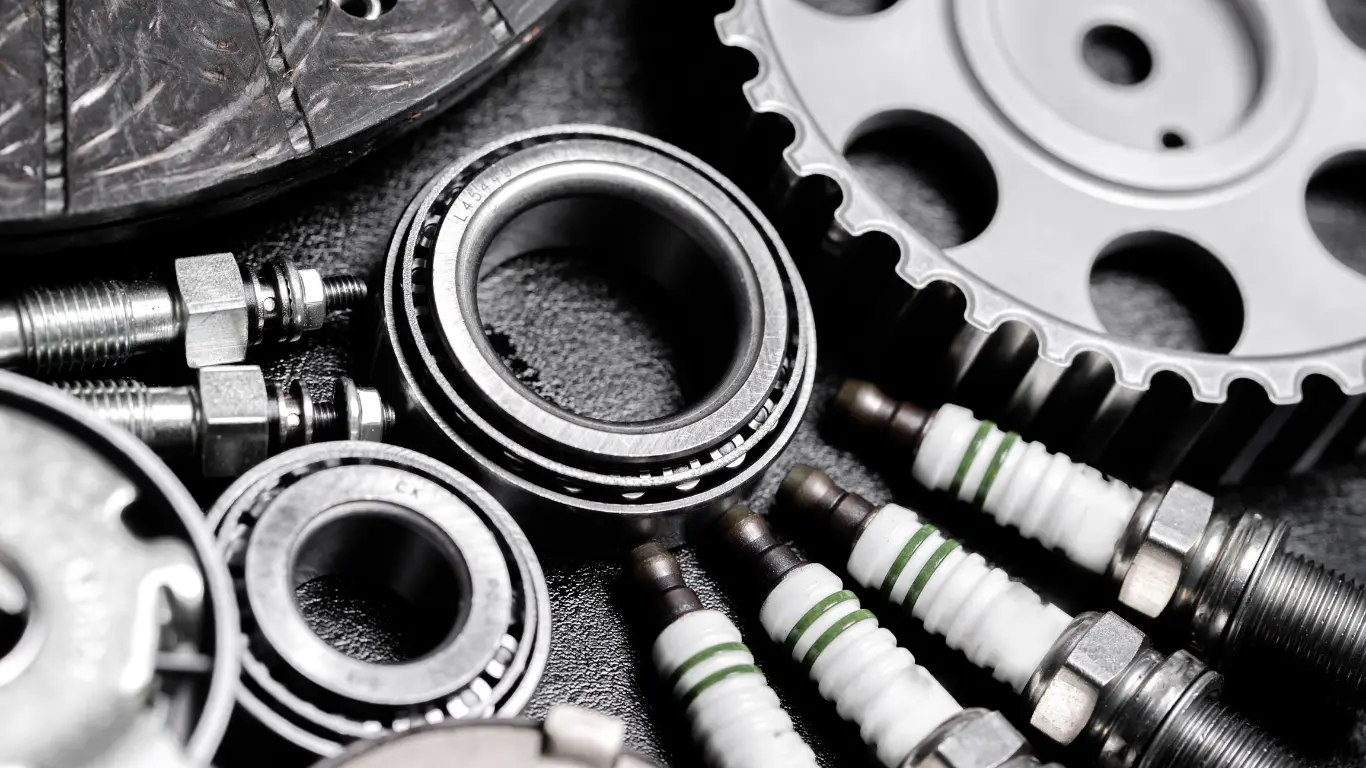 Se ven bujias, anillas, y otros productos sobre fondo gris.